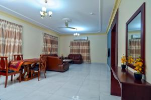 a living room with a table and a couch at Fursan Apartment in Manama