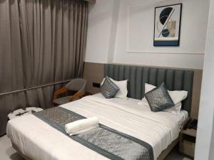 a hotel room with a large bed with black and white pillows at Hotel Leaf inn in Ahmedabad