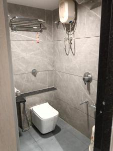 a small bathroom with a toilet and a shower at Hotel Leaf inn in Ahmedabad +6 photos