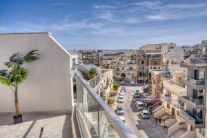 a view of a city from the balcony of a building at St Julian s Luxury Laura Apartments in Is-Swieqi