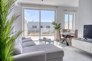a living room with a couch and a table at St Julian s Luxury Laura Apartments in Is-Swieqi