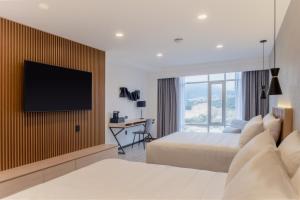 a hotel room with two beds and a flat screen tv at Hotel Luure Bosque Real in Mexico City +13 photos