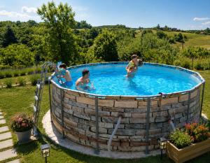 a group of people in a circular pool in a yard at Guesthouse Mreznica- Mreznicka Idila resort in Galović-Selo
