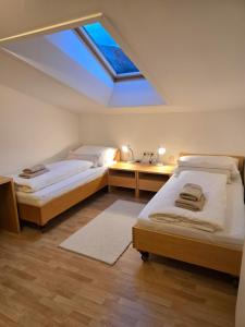 two beds in a room with a skylight at Ferienwohnung Felder in Bürs