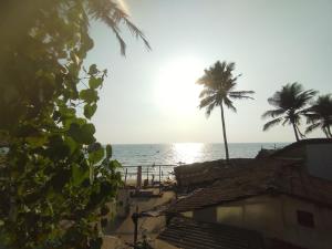 a view of a beach with palm trees and the ocean at NEW BEACH HOTEL Anjuna in Anjuna