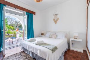 a bedroom with a large bed and a balcony at Vivenda Aromas do Algarve in Monte Raposo