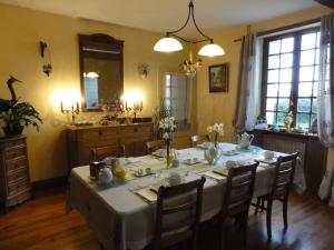 comedor con mesa y cocina en Le Clos des Bérengeries, en Saint-Patrice