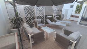 an outdoor patio with chairs and an umbrella at Archimede29 in Syracuse