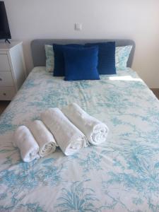 two towels on a bed with a blue and white comforter at Monte Gordo Beach Sky Flat in Monte Gordo