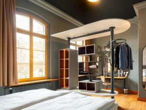a bedroom with a canopy bed and a closet at WELTRAD Parkhotel am Fluss in Schönebeck