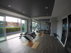 a gym with treadmills and ellipticals and a large window at Me Condo by SN in Rayong