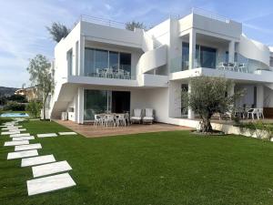 a large white house with a lawn in front of it at Like at Home - Boutique A6 Sea view, Private Terrace & Pool in Palau