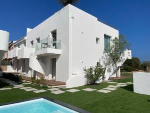 a white house with a swimming pool in front of it at Like at Home - Boutique A6 Sea view, Private Terrace & Pool in Palau