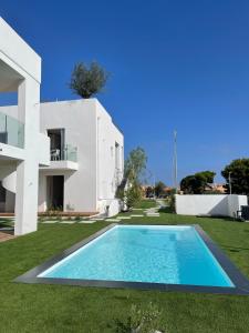 a villa with a swimming pool in front of a house at Like at Home - Boutique A6 Sea view, Private Terrace & Pool in Palau