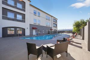 a hotel with a swimming pool and chairs and a building at Sonesta Essential Hotel Houston-I-45 Spring in Houston