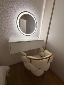 a bathroom with a round mirror and a chair at Apartman Maja in Prijedor