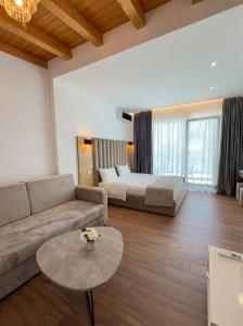 a living room with a couch and a bed and a table at Don Mare in Dhërmi +23 photos