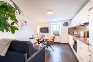 a kitchen and living room with a couch and a table at Eifel Quartier im Herzen von Mendig in Mendig