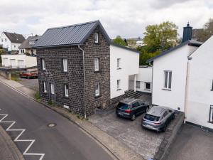 a building with two cars parked in a parking lot at Eifel Quartier im Herzen von Mendig in Mendig