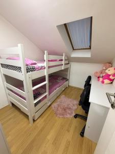 a small room with two bunk beds and a desk at Apartman Maja in Prijedor