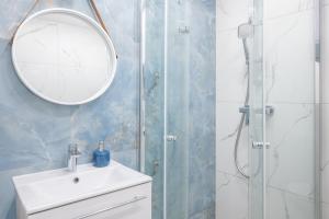 a bathroom with a shower and a sink and a mirror at Nadmorski Bursztyn - Błękitna in Rowy +279 photos