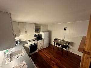 a small kitchen with white appliances and a table at Sjøveien 43 in Vestvågøya +3 photos