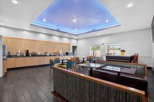 a restaurant with tables and chairs and a kitchen at Sonesta Essential Hotel Houston-I-45 Spring in Houston
