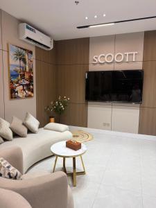 ein Wohnzimmer mit Sofa und Fernseher in der Unterkunft سكوت Scoott in Dschāzān