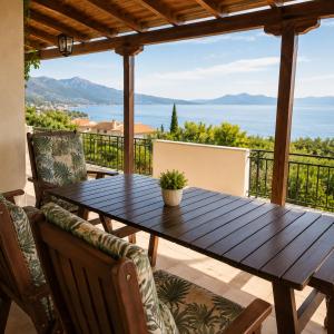 a wooden table on a patio with a view of the ocean at Aegina Breeze House in Egina