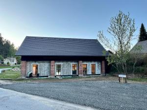 a small brick house with a black roof at Stodola Klokočí in Klokočí