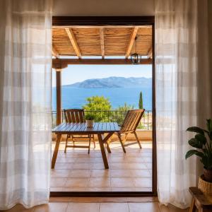 a patio with a table and two chairs on a balcony at Aegina Breeze House in Egina