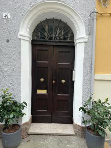 a large wooden door with an arch in a building at Suite Cerchio 2 - City Center in Ravenna