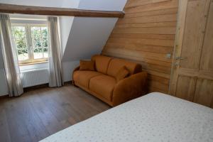 a bedroom with a couch and a window and a bed at Vakantiehuis Lisette in Veurne