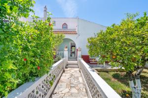 a white house with orange trees in front of it at Vivenda Aromas do Algarve in Monte Raposo