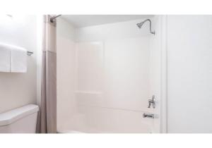 a bathroom with a shower and a toilet and a sink at Motel 6-Carlsbad, CA Beach in Carlsbad