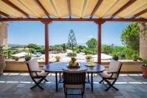 a patio with a table and chairs with a view at Villa Ersilia in Egina