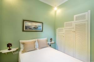 a bedroom with a white bed and white cabinets at Villa Ersilia in Egina +33 photos