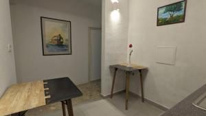 a room with a table and a vase with a flower on it at Olea Rooms Piran Old Town in Piran