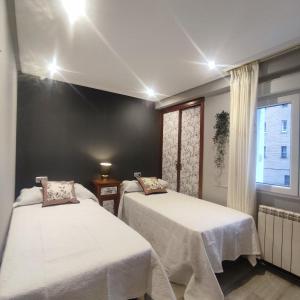 a room with two beds and a window at Apartamento céntrico Irene IV in Avilés