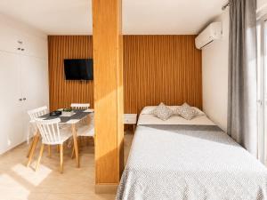 a bedroom with a bed and a table and a television at Benalbeach loft in Benalmádena +24 photos