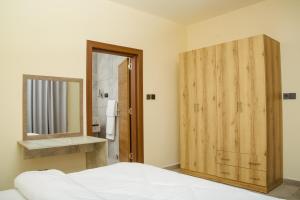 a bedroom with a wooden door and a mirror at Venue 360 Hotel in Freetown