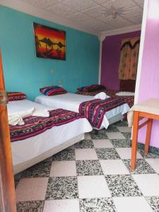 two beds in a room with blue walls at Hotel Casa Ramos in Panajachel +9 photos
