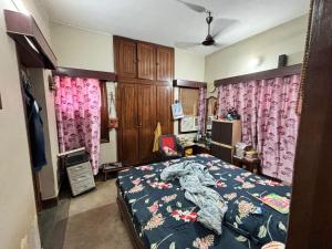 a bedroom with a bed and some pink curtains at Rishi niwas in Darbhanga