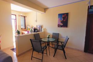 a dining room and kitchen with a table and chairs at The Nest Apartment Darad in Ukunda Airport