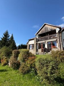 a stone house on a hill with bushes at Penzion u Zdichynců in Kubova Huť