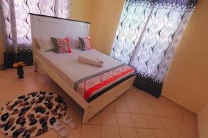 a small bed in a room with a curtain at The Nest Apartment Darad in Ukunda Airport