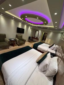 a hotel room with two beds and a purple ceiling at Nile Royale Hotel in Cairo