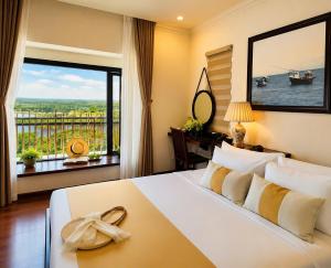 a bedroom with a large bed with a large window at Happy Life Memories Hoi An Hotel & Spa in Hoi An