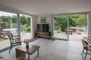 a living room with a television and a patio at La Loge du Pic Noir in Dabo
