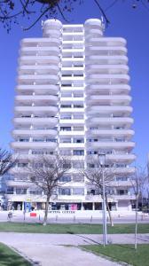 a tall white building with trees in front of it at Monte Gordo Beach Sky Flat in Monte Gordo